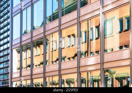 Reflektierendes Glas faÁade eines modernen Bürogebäudes mit verzerrten Reflexionen der umgebenden Architektur, Stockholm, Schweden Stockfoto