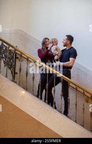Eine dreiköpfige Familie mit einem Mann, einer Frau und einem Kind lächelt und steht zusammen auf einer Treppe. Cleveland, Ohio, USA Stockfoto