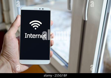 Eine Person sieht eine weiße Beschriftung auf einem schwarzen Smartphone-Display, das in der Hand hält. Internet Stockfoto