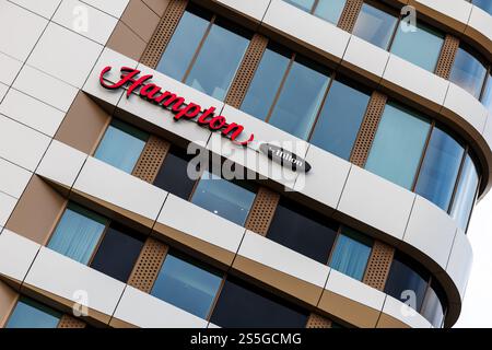 München, Deutschland. Januar 2025. Der Hampton by Hilton Schriftzug und das Logo sind am 10. Januar 2025 an der Fassade eines der Hotels der Hotelkette in München (Bayern) zu sehen. Hampton by Hilton ist eines der größten Hotel-Franchise-Unternehmen in den USA. Quelle: Matthias Balk/dpa/Alamy Live News Stockfoto