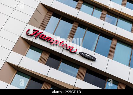 München, Deutschland. Januar 2025. Der Hampton by Hilton Schriftzug und das Logo sind am 10. Januar 2025 an der Fassade eines der Hotels der Hotelkette in München (Bayern) zu sehen. Hampton by Hilton ist eines der größten Hotel-Franchise-Unternehmen in den USA. Quelle: Matthias Balk/dpa/Alamy Live News Stockfoto