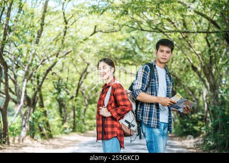 Sowohl männliche als auch weibliche Touristen tragen ihre Rucksäcke und wenden sich gegeneinander. Stockfoto