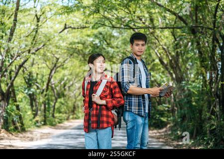 Sowohl männliche als auch weibliche Touristen tragen ihre Rucksäcke und wenden sich gegeneinander. Stockfoto