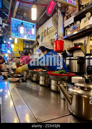 Street Food-Anbieter kocht koreanisches Essen an einem Marktstand in der Kalguksu Alley im Namdaemun Market in Seoul, Südkorea. Stockfoto