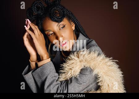 Eine atemberaubende junge Frau zeigt ihre einzigartige Frisur und Mode in einem eleganten Ambiente. Stockfoto