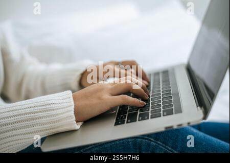 Eine Frauenhand, die auf einen Laptop gelegt wird. Selektiver Fokus. Stockfoto