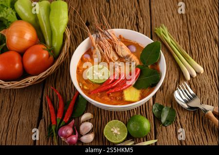 Tom Yum Kung Thai heiße scharfe Suppe Garnelen mit Zitronengras, Zitrone, Galgant und Chili auf hölzernem Hintergrund Thailand Essen Stockfoto