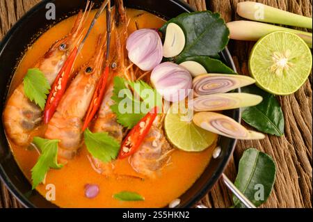 Tom Yum Kung Thai heiße scharfe Suppe Garnelen mit Zitronengras, Zitrone, Galgant und Chili auf hölzernem Hintergrund Thailand Essen Stockfoto