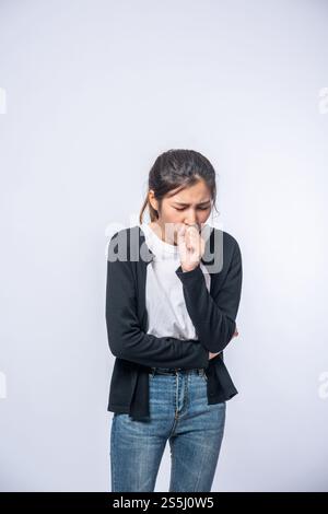 Eine Frau, die hustet und ihren Mund mit der Hand bedeckt Stockfoto