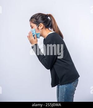 Eine Frau, die hustet und ihren Mund mit der Hand bedeckt Stockfoto