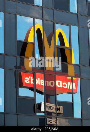 Gespiegelt, McDonald's Logo, McDonald's Schild, Reflexion, Glasgebäude, ungewöhnlich, unsichtbar, ungewöhnlich, einzigartig, Ansicht, Konsum, Marketing, Unterscheidungskraft Stockfoto