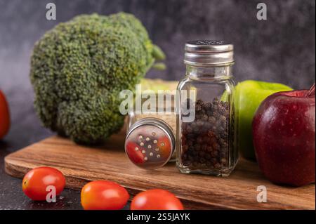 Apfel auf einem Holzbrett mit einem Glas Pfeffersamen. Selektiver Fokus. Stockfoto
