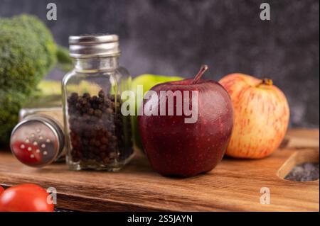Apfel auf einem Holzbrett mit einem Glas Pfeffersamen Stockfoto