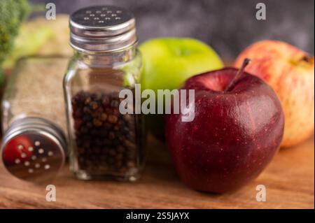 Apfel auf einem Holzbrett mit einem Glas Pfeffersamen Stockfoto