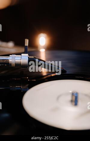 Nahaufnahme eines Stylus für Schallplatten-Player mit warmem Licht, der analoge Musik-Vibes einfängt Stockfoto