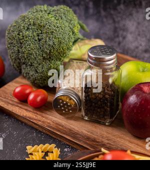 Apfel auf einem Holzbrett mit einem Glas Pfeffersamen. Selektiver Fokus. Stockfoto
