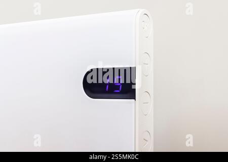 Nahaufnahme der Messung der Raumtemperatur. Moderner elektrischer Heizkörper an der Wand, Innenraum, Großbritannien Stockfoto