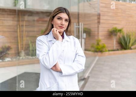 Porträt der jungen Latina-Ärztin vor dem Glaseingang draußen Stockfoto