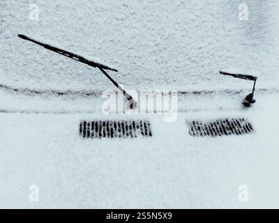 Die Scheibenwischer sind nach dem Winterschneesturm mit geparktem Auto bedeckt, im Schnee gefroren Stockfoto