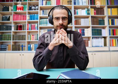 Webcam-Ansicht junger sprechender Mann, der Videoanruf-Chat-Konferenz in der Bibliothek macht Stockfoto