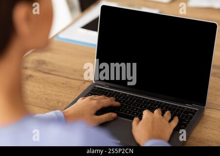 Lady arbeitet auf Laptop mit leeren schwarzen Bildschirm für mockup Stockfoto