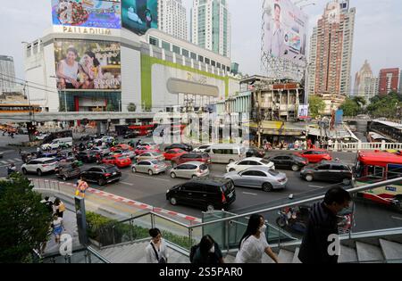 Bangkok, Thailand - 17. Februar 2023: Menschen, die Gesichtsmasken tragen, betreten eine Fußgängerbrücke in der Nähe des schweren Autoverkehrs in der Innenstadt. Stockfoto