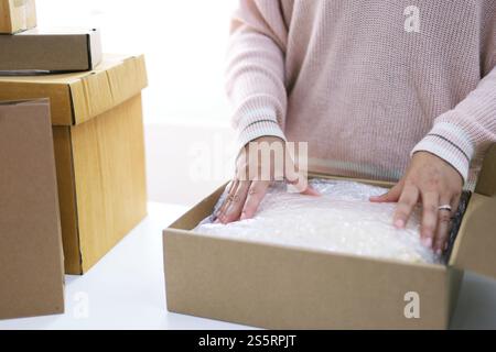 Business von zu Hause Frau Vorbereitung Paket Lieferkasten Versand für den Online-Shopping. Junge Start bis Kleinbetrieb Besitzer zu Hause online bestellen Stockfoto