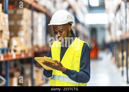 Ein afrikanischer Lagerarbeiter, der Inventar im Lagerraum nimmt Stockfoto