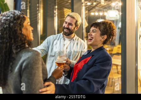 Multi-ethnische glückliche moderne Freunde gratulieren einer Frau während der Abendparty auf der Bar Terrasse Stockfoto