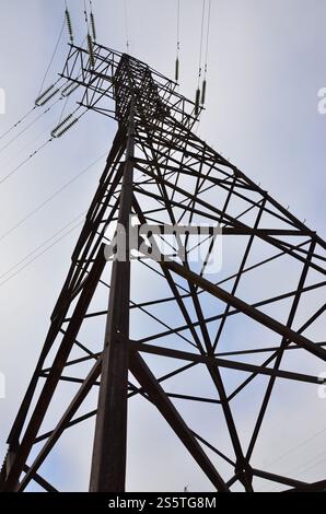 Hochspannungs-Elektroturm. Konzept der Stromleitungen. Tageszene im Freien mit klarem blauem Himmel. Hochspannungs-Elektroturm. Stromübertragungspylon Stockfoto