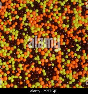 Hintergrundbild einer Vielzahl von farbigen glasierten Pulvern in Form von kleinen Kugeln. Eine große Anzahl von süßen, bunten Perlen von sehr kleiner Größe für Stockfoto