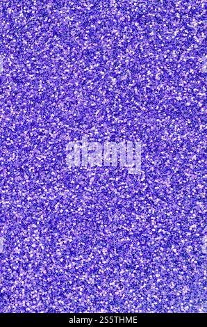 Violette dekorative Pailletten. Hintergrundbild mit glänzenden Bokeh-Lichtern von kleinen Elementen, die Licht reflektieren. Violette dekorative Pailletten. Hintergrund Stockfoto