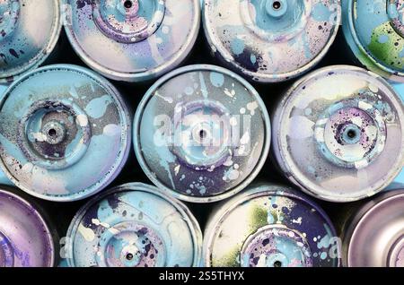 Einige gebrauchte Sprühdosen mit blauen Farbtropfen liegen auf Texturhintergrund von Mode pastellblauem Farbpapier in minimalem Konzept. Ein paar gebrauchte Sprühdosen Stockfoto