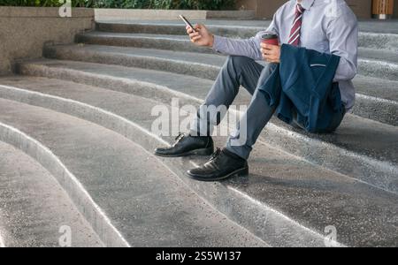 Geschäftsmann zeigt leere Visitenkarte und hält Smartphone. Geschäftsmann hält weißen leeren Kartenraum für Text. Produktanzeige Stockfoto