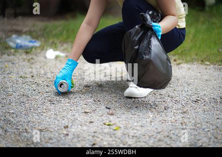 Freiwillige Wohltätigkeitsfrau Hand hält Müll schwarze Tasche und Plastikflaschenmüll für Recycling für Reinigung im Park Freiwilligenkonzept Reuse und vo Stockfoto