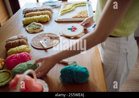 Stanznadel. Asiatische Frau, die handgemachtes Hobby-Stricken in der Atelierwerkstatt herstellt. Designer-Arbeitsplatz Handgefertigtes Bastelprojekt DIY Stickkonzept Stockfoto