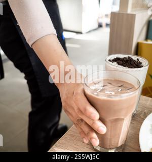 Eine Kellnerin serviert bestellte Getränke für Gäste in einem Restaurant Stockfoto