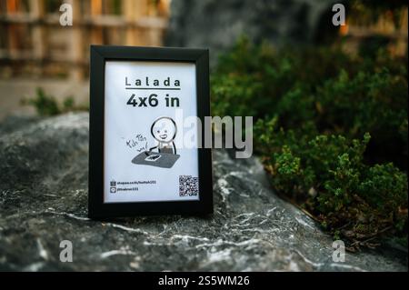 Werbebrett mit schwarzem Rahmen auf dem Stein im Garten Stockfoto