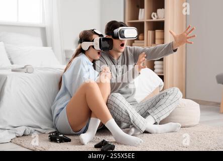 Verängstigte junge Paare mit VR-Brille im Schlafzimmer Stockfoto