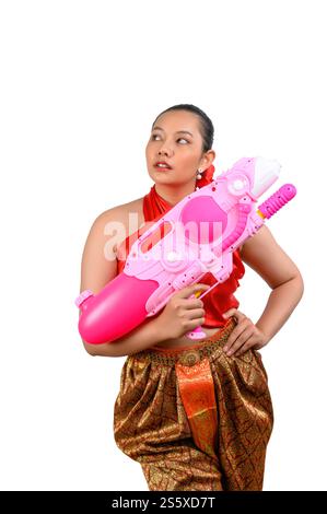 Porträt schöne Frau im Songkran Festival mit traditioneller thailändischer Tracht stehend und mit Wasserpistole mit Lächeln und Kamera auf weiß Stockfoto