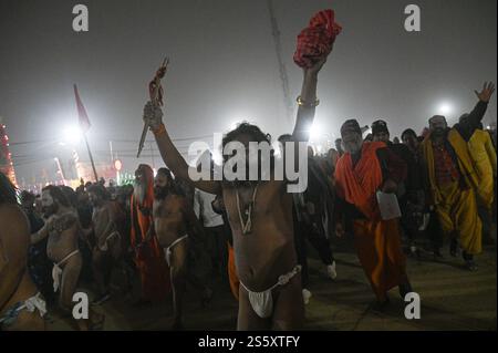 Prayagraj, Uttar Pradesh, Indien. Januar 2025. Ein Naga Sadhu oder ein hinduheiliger Mann läuft während einer Prozession, bevor er ein heiliges Bad in Sangam nimmt, wo die heiligen Flüsse Ganges, Yamuna und mythische Saraswati treffen, während der Maha Kumbh Mela in Prayagraj, Uttar Pradesh, Indien, am 14. Januar 2025. (Kreditbild: © Kabir Jhangiani/ZUMA Press Wire) NUR REDAKTIONELLE VERWENDUNG! Nicht für kommerzielle ZWECKE! Stockfoto