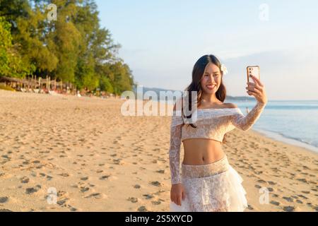 Influencer Lifestyle Woman Creating Content on Tropical Beach at Dusk Concept Stockfoto