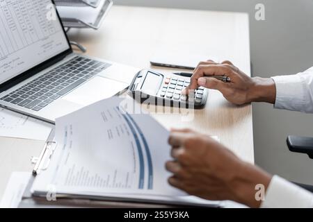 Geschäftsmann Buchhalter Analyse von Investitionsdiagrammen Rechnung und Drücken von Rechnerschaltflächen über Dokumenten. Buchhalter, Sachbearbeiter, Bankberater Stockfoto
