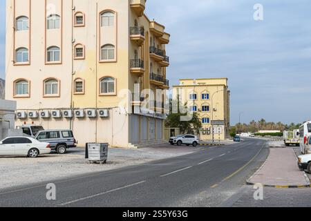 Khasab, Oman - 1. Januar 2025: Eine ruhige Straßenszene mit Wohngebäuden, geparkten Autos und einem klaren Himmel, die die ruhige Atmosphäre von einfangen Stockfoto