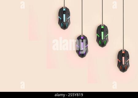 Mehrere Computermäuse hängen auf einem pastellfarbenen Pfirsichhintergrund. Das Konzept kooperativer Computervideospiele, die Verwendung von Auto-Clicker und Pay-per-Click Stockfoto