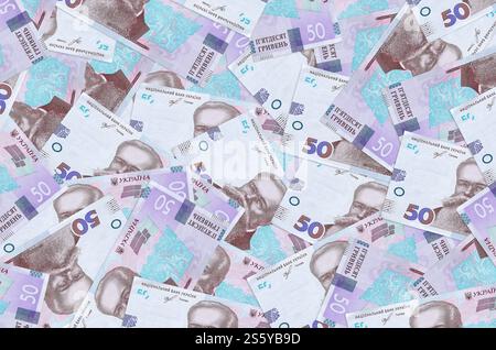 50 ukrainische Hrywnja-Scheine liegen auf einem großen Haufen. Konzeptioneller Hintergrund des reichen Lebens. Viel Geld. 50 ukrainische Hrywnja-Scheine liegen auf einem großen Haufen. Stockfoto
