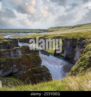 Der Fluss Fjadra fließt durch den wunderschönen Canyon Fjadrargljufur. Südisland. Bewölkter Herbsttag. Es liegt in der Nähe der Ringstraße, nicht weit entfernt Stockfoto