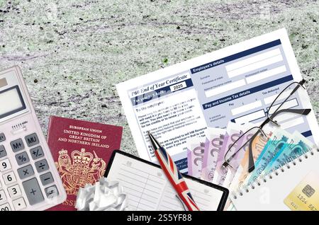 Englisch Steuerformular P60 Jahresabschluss-Zertifikat von HM Income and Customs liegt mit Büroartikeln auf dem Tisch. HMRC-Papiere und Steuerzahlungsprozess in Stockfoto
