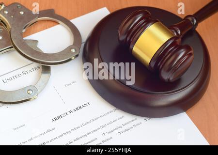 Justizhammer und Haftbefehl, Blankodokument mit Polizeihandschellen aus nächster Nähe. Justizhammer und Haftbefehl geben ein unbeschreibliches Dokument mit der Polizei Stockfoto