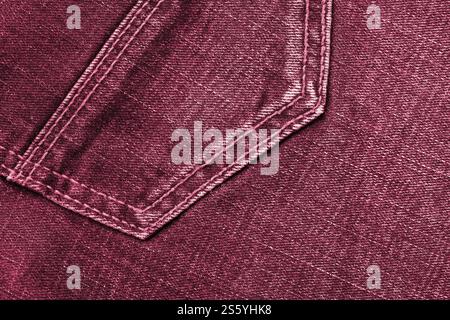 Detaillierte abstrakte Textur aus dunkelblauem Denimstoff. Hintergrundbild des alten gebrauchten Denim-Hosenstoffes Nahaufnahme Bild getönt in Viva Magenta, Farbe von Stockfoto